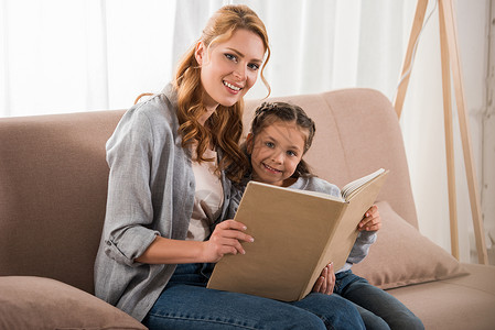 幸福的母亲和女儿一起在家里阅读书在照图片