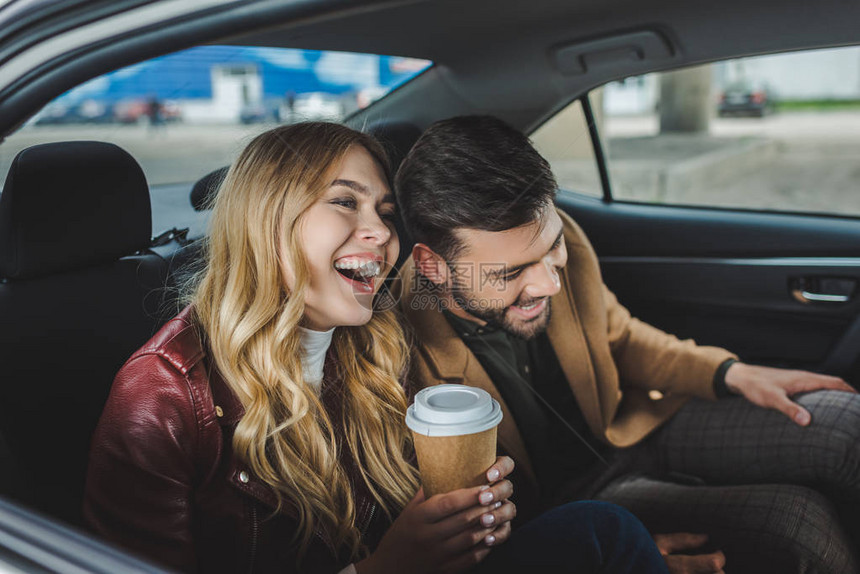 快乐的年轻夫妇在坐出租车时笑着图片