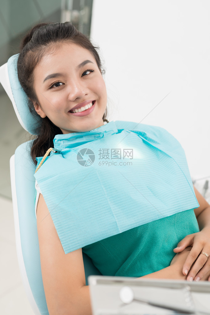 坐在牙科椅上的一位微笑的女病图片