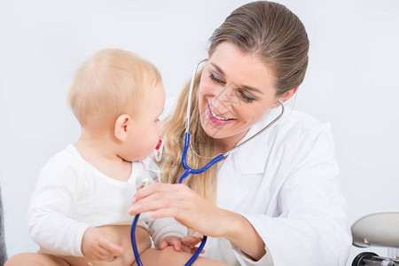 在现代医疗中心对可爱健康的女婴进行例体检时使用听诊器的专图片
