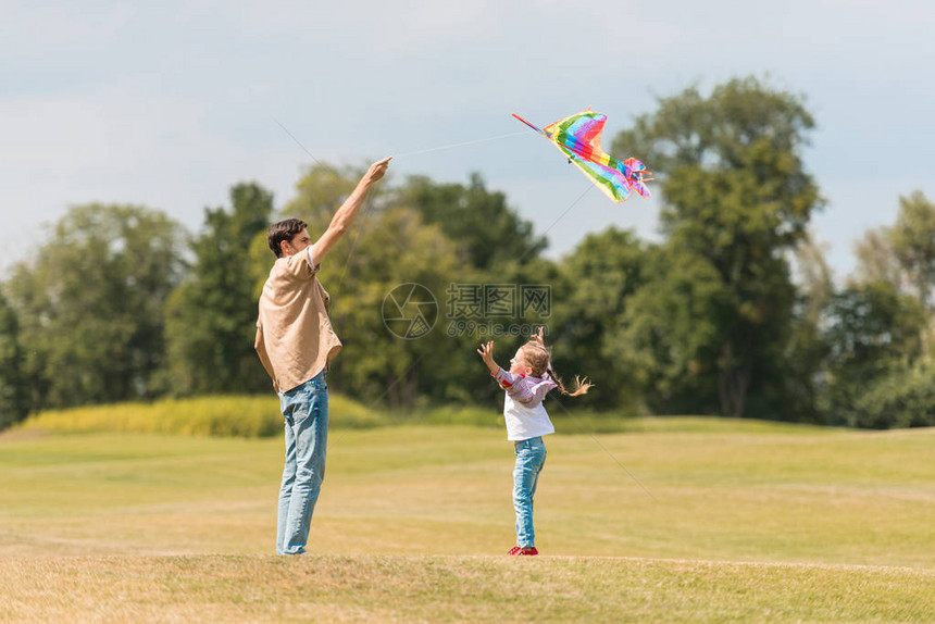 快乐的父亲和女儿的一面在公园里玩图片