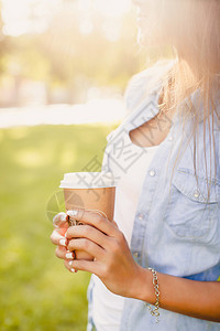 带着咖啡积极情绪可爱情感穿着时装牛仔裤衬衫温暖的阳光颜色图片