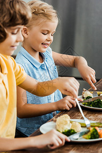 儿童在吃健康蔬菜时笑图片