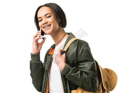 带着背包在智能手机上说话的非洲女学生在图片