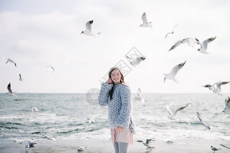 穿着墨里诺毛衣的快乐年轻女孩在冬季图片