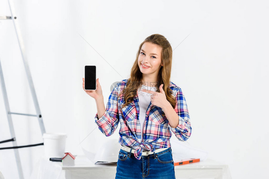 女孩指着智能手机看着相机图片