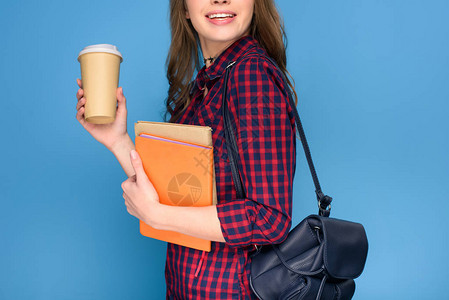 年轻学生拿着背包书本和咖啡站立的景象图片