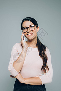 美丽的微笑着的女士在眼镜中说话用智能手机图片