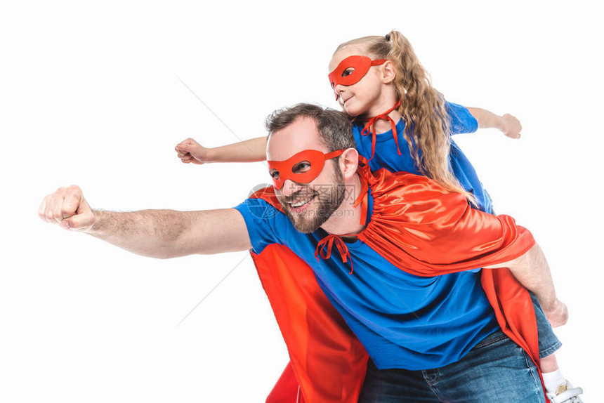 快乐的父亲和女儿穿着超级英雄服装假装飞着白图片