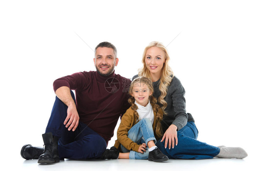 家人和女儿坐在冬天的衣着中在白图片