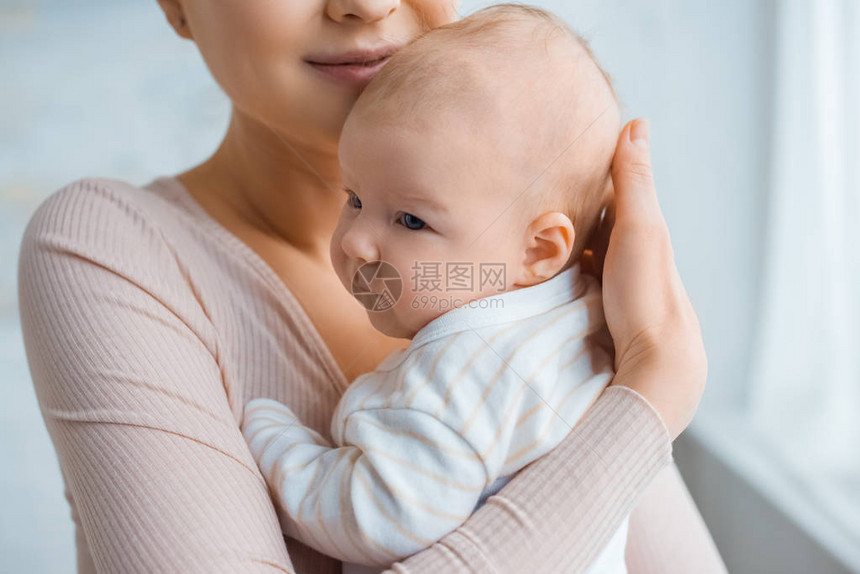 在家里抱着可爱婴儿的幸福母亲被拍图片