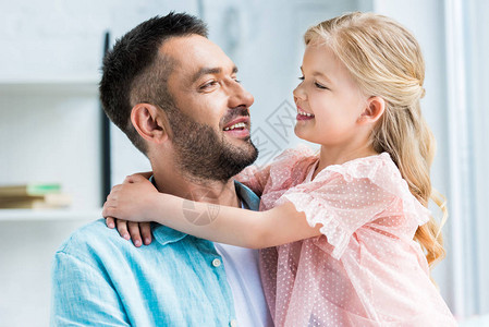 快乐的父亲和女儿在家中拥抱和微笑图片