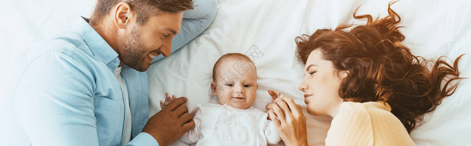 快乐父母轻地抚摸可爱的婴儿图片