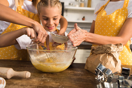 母亲和祖母在厨房一起准备面粉的幸福儿童节图片