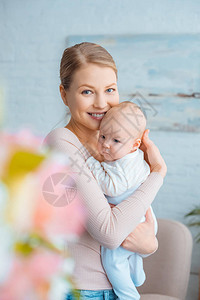 有选择焦点快乐的年轻母亲拥抱可爱的婴儿图片