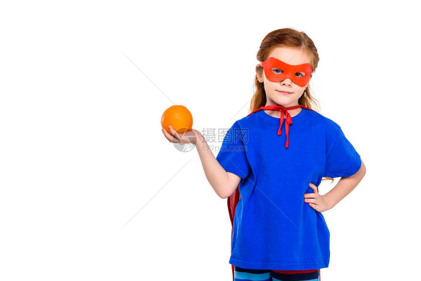 戴着面罩和斗篷的超级孩子拿着橙子图片