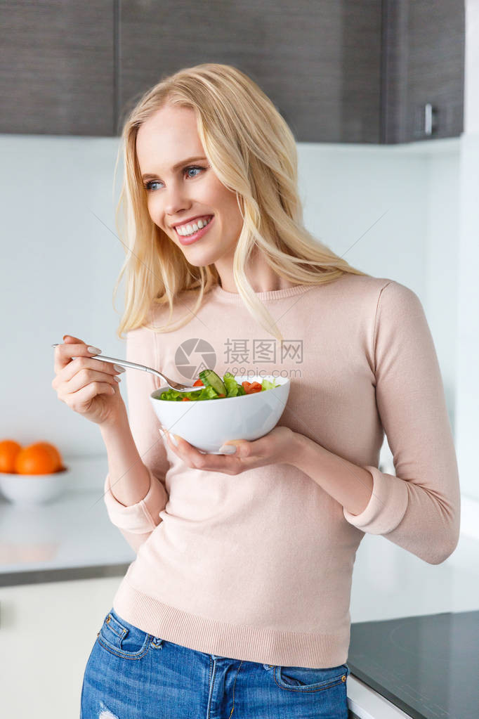 带着一碗新鲜蔬菜沙拉的美丽笑着微图片