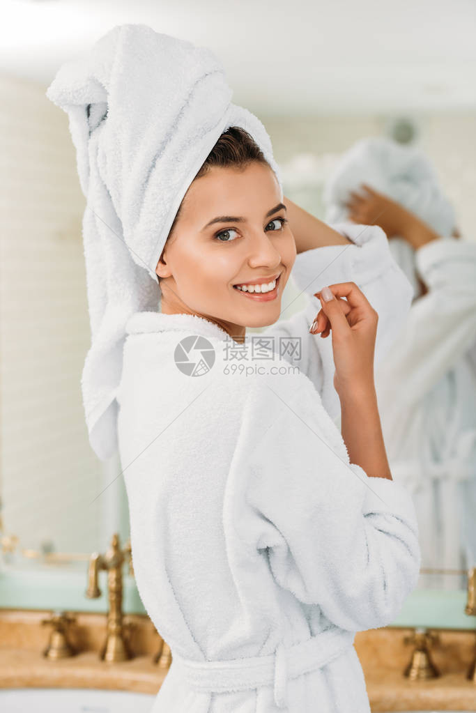 穿着浴袍和头顶毛巾的有魅力的年轻女子在浴室里图片