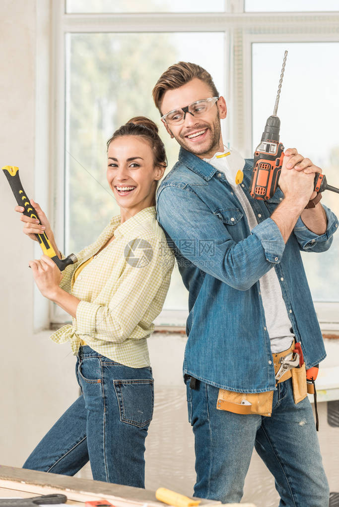 幸福的年轻夫妇在修理房屋期间拿图片
