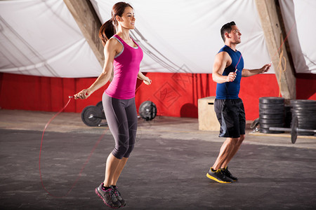 男女青年在交叉体操馆锻炼时跳绳子图片