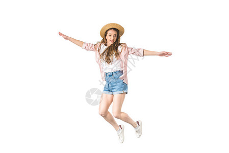 戴着帽子的快乐女孩用张开的双臂跳起图片
