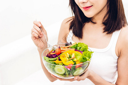 快乐的女人在碗里吃和展示健康的新鲜沙拉节食概念健康的生活方图片