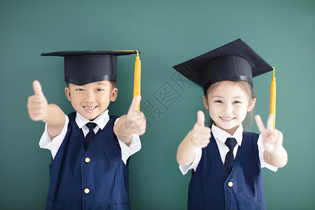 快乐的男孩女在毕业帽图片