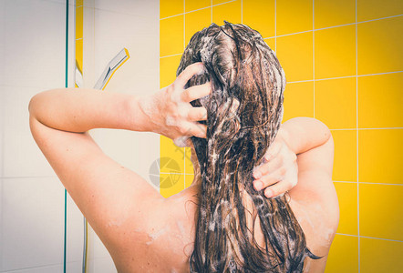 有魅力的女人在淋浴时用洗发水洗图片