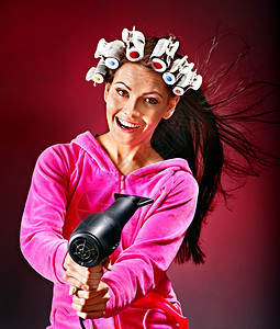 幸福的女人戴着卷发夹拿着吹风机背景图片