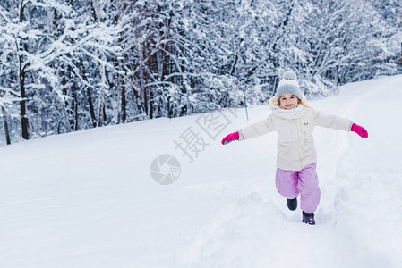 可爱的快乐孩子手伸着手套在雪中跑动笑图片