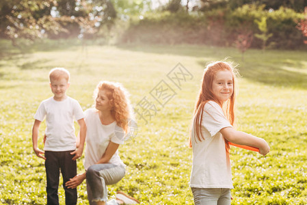 快乐的孩子玩飞盘母亲和兄弟图片