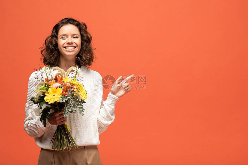 穿着秋服的快乐女人拿着一束鲜花用手指图片