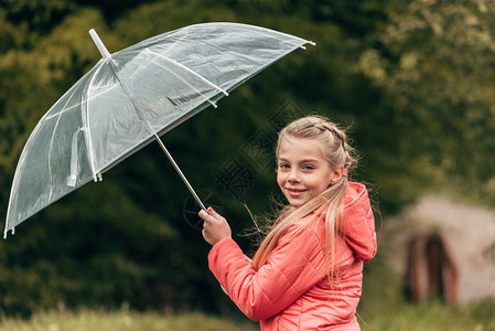 可爱的小孩拿着雨伞在秋天公园图片