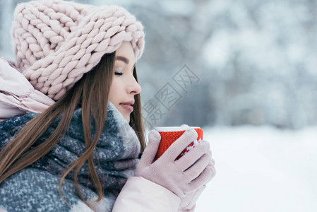 美丽的年轻美女的一面手握着一杯咖啡热咖啡冰雪公图片