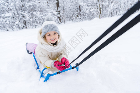 可爱的小孩躺在雪橇上笑着在图片