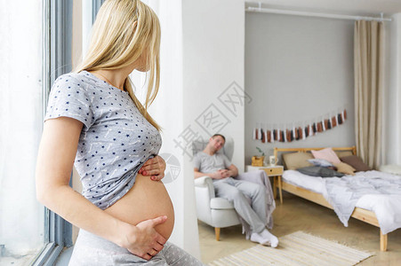 怀孕妻子对住在家中坐在椅子上的丈夫充满图片