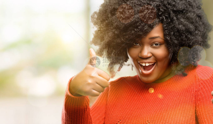美丽的非洲女笑着向摄影机展示举起手势的拇指图片
