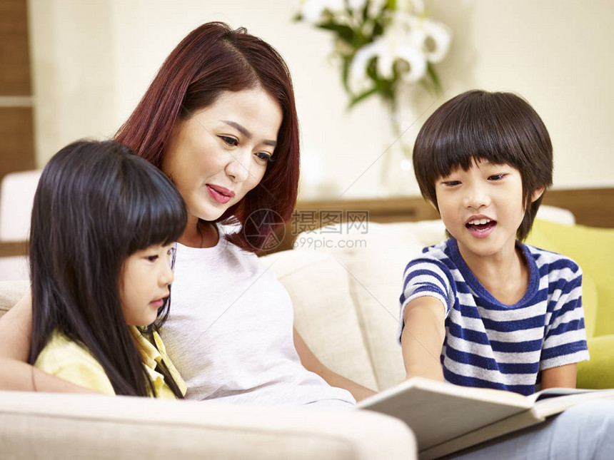 年轻的年幼母亲和她的儿子和女儿坐在沙发上图片