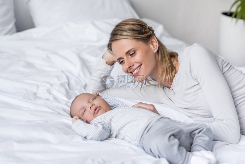 微笑的母亲与睡着的婴儿图片