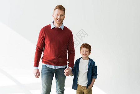 快乐的红发父亲和儿子手牵笑着图片