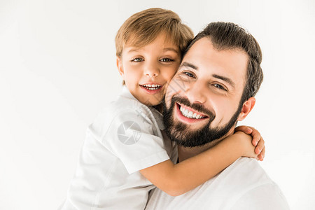 快乐的父亲和儿子拥抱并微笑的肖像照片在图片