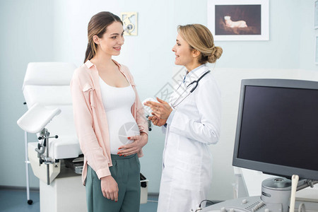 在诊所与微笑的妇科医生进行咨询后孕图片