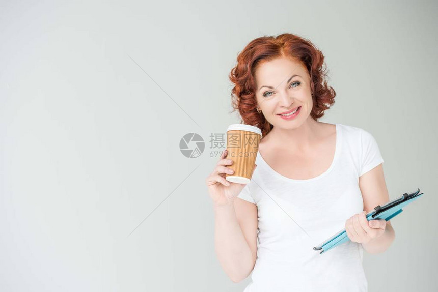 成年红发成年妇女喝咖啡和使用数字平板电脑图片
