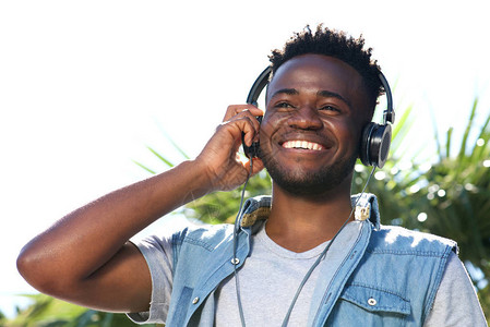 以耳机收听音乐的年轻黑人快乐青图片