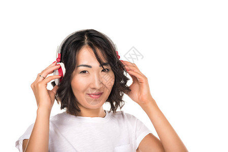 美丽的美丽和快乐的亚洲女人用耳机听音乐在图片