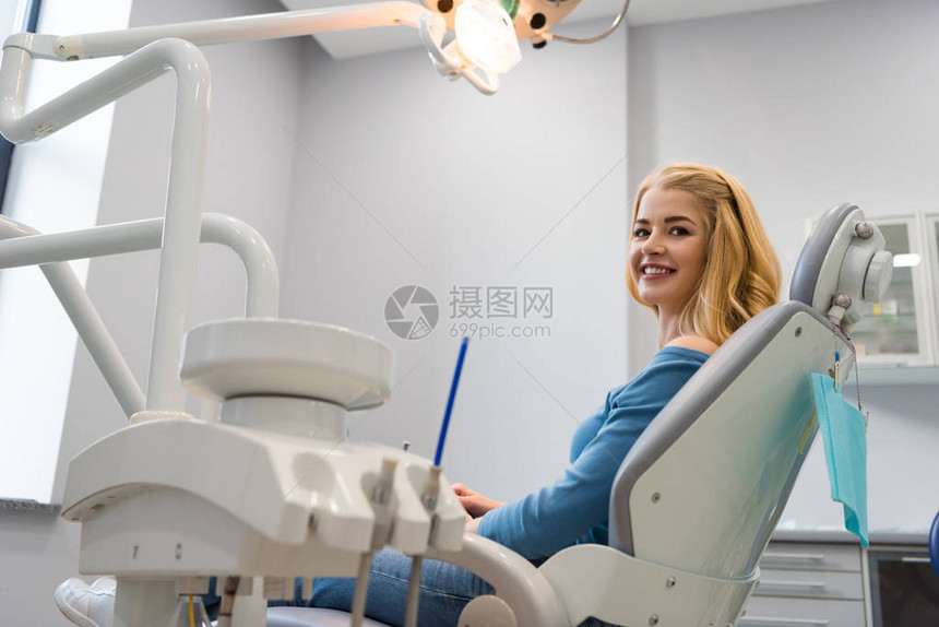 坐在牙医办公室牙科椅上的年轻图片