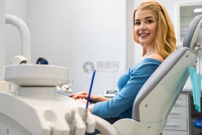 坐在牙医办公室牙科椅上的笑着微图片