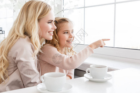 母女俩在咖啡馆喝茶时看着窗外图片