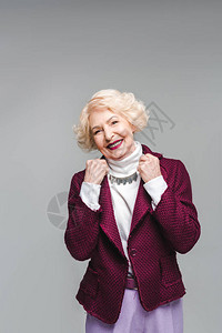 穿着时装衣服的老女人笑着微笑和被灰色隔图片