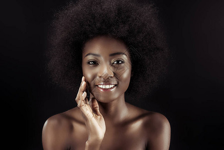 快乐的非洲美国女人触摸着她的脸庞图片